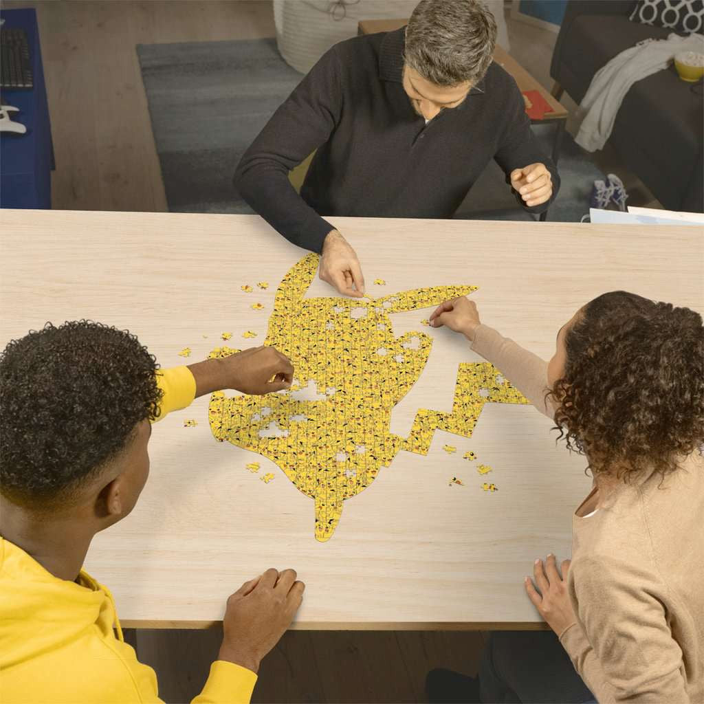 Een verzamelaar legt de laatste stukjes van de grote Pikachu vormpuzzel op een tafel.