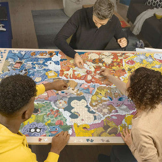 Een fanatieke verzamelaar werkt aan de gigantische 5000-stukjes Pokémon puzzel op een grote tafel.