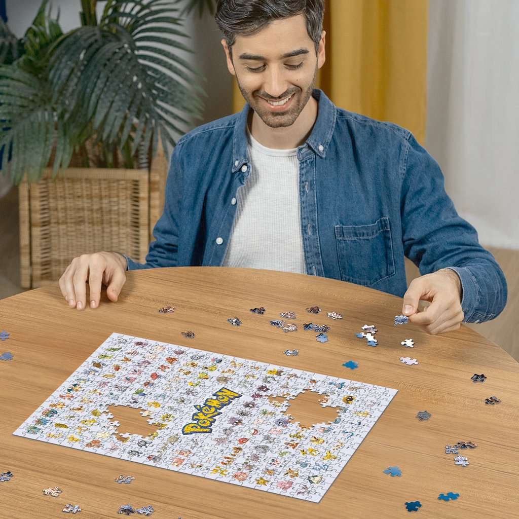 Een verzamelaar legt de laatste hand aan de 500-stukjes Pokémon poster puzzel.